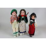 Three Armande Marseille bisque head dolls, each numbered 390 and wearing costumes, tallest 31cm