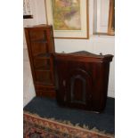 A mahogany hanging corner cupboard with single arched panel door enclosing two shelves, together