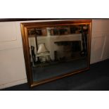 A contemporary rectangular gilt framed beveled glass wall mirror 136cm by 106cm