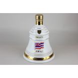 A Wade porcelain decanter in the shape of a bell, containing 75cl of Bells 12 year old special