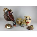 Five various Balinese masks in wood, brass and papier mache, together with an African mask of a