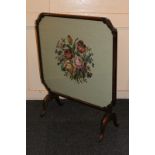 A framed tapestry card table/fire screen, with carved corner detail on curved legs, 70cm by 65cm