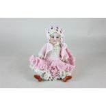 A mid 20th century American porcelain jointed doll with sleeping eyes and closed mouth, in knitted