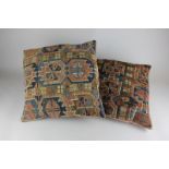 Two Middle Eastern cushions made from saddlebags with geometric shapes in red, blue and brown