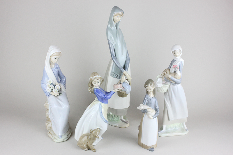 Four Lladro figures of women and girls holding various items, a pig, lilies, a chicken and a