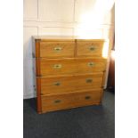 A brass bound teak campaign secretaire chest, the top drawer opening into a writing desk with pigeon