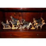 A collection of fifteen German shepherd dog ornaments including Beswick, Royal Doulton and Aynsley