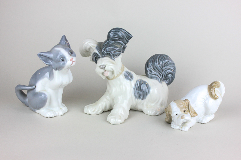 A Lladro porcelain figure of a dog, a Lladro cat figure and a Nao spaniel figure