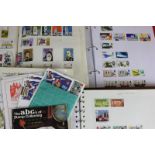 A collection of various stamps housed in three books, including Olympic stamps, sporting and