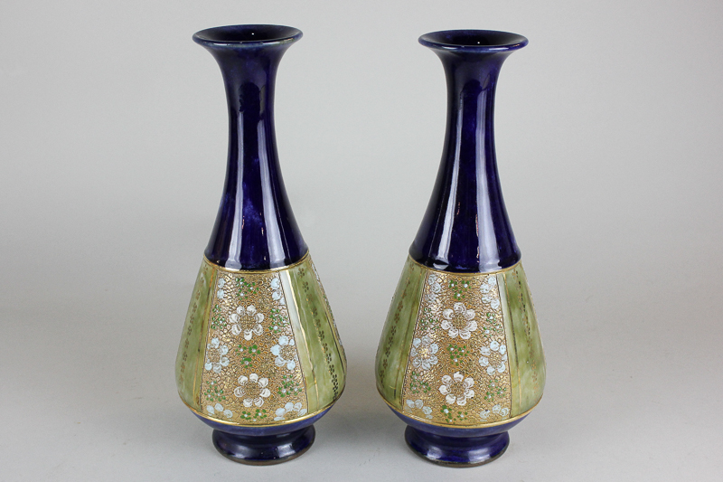 A pair of Royal Doulton blue and gilt pear shaped vases with floral panels, 28cm high