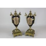 A pair of black metal urns with copper and brass details, 33cm high