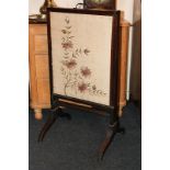 A Victorian mahogany framed fire screen with extending rectangular floral tapestry screens on twin
