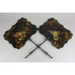 A pair of Victorian black lacquered papier mache face screens with floral and gilt embellishment