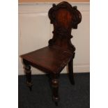 An oak hall chair with carved scroll back, on turned legs
