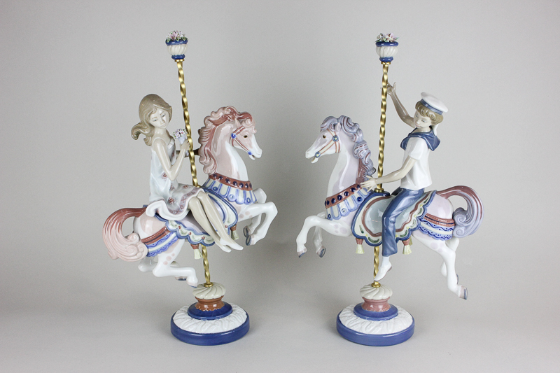 A pair of Lladro porcelain figures  of a boy and a girl on carousel horses (reference 1469 and