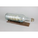 A three masted ship in a Teachers glass bottle on stand, 29.5cm long