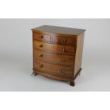 A miniature mahogany chest of drawers with two short over three long drawers on bracket feet