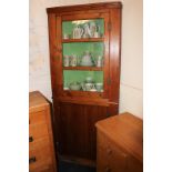 A Victorian pine corner cupboard with glazed door enclosing three shelves above cupboard, 82cm