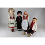 A collection of dolls in various costumes including Scottish and Russian boy dolls and a German girl