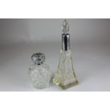 A George V silver mounted cut glass dressing table bottle, together with a silver topped glass