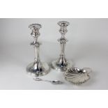 A pair of silver plated column candlesticks, a shell shaped butter dish and a teaspoon