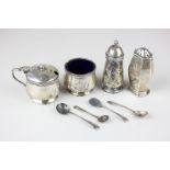 A George V silver cruet with decorative border and blue glass liners, an Art Deco silver pepper, two