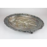 A Sheffield silver plated meat dish with leaf scroll border, gravy gully, on four claw and ball