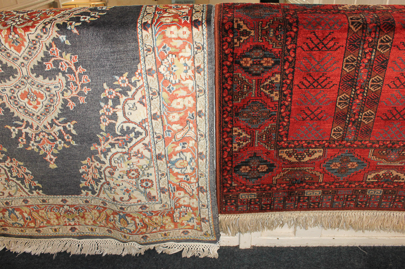 A Persian rug with terracotta and cream central medallion on grey ground within floral terracotta