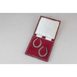 A cased pair of Elizabeth II silver napkin rings modelled as horseshoes maker Francis Howard Ltd,