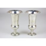 A pair of George V silver urn shape vases on loaded circular bases with flared rims, maker William