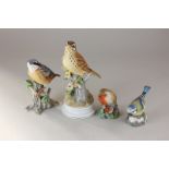 Two Royal Worcester porcelain models of birds, a robin and a bluetit, together with two Spanish