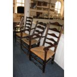 Three similar ladderback armchairs with rush seats, one on turned supports (3)