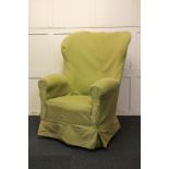 A wingback armchair with rocking spring action, on front bun feet and castors, (cover distressed)