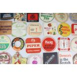 A collection of cardboard beer mats including Guinness, Bass, Britvic and others