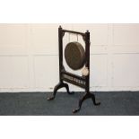 A brass dinner gong on mahogany stand with striker, on played feet, 51cm