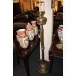 A Victorian brass oil lamp converted for use as a standard lamp, with reeded stem on circular base