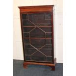 A mahogany bookcase with single glazed panel door enclosing three shelves, on shaped bracket feet,