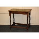 An oak side table with leather inset rectangular top, on turned legs and stretcher support, 76cm