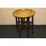 A North African brass tray top table on folding turned supports, 53.5cm