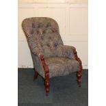 A Victorian button back armchair upholstered in William Morris style fabric, on turned baluster