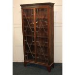 A mahogany bookcase with twin panel glazed doors enclosing three adjustable shelves, on short