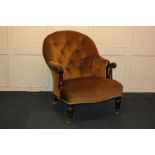 A Victorian button back armchair with gold upholstery and scrolled arms, on turned front legs (later