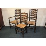 Two rush seated ladder back carver dining chairs and a matching single chair