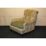 A Victorian Howard style upholstered armchair, on turned square front legs and castors