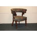 An upholstered tub chair with central carved splat, in green and red patterned fabric, on turned