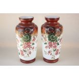 A pair of painted white glass vases, each with floral design and red rim, 28cm high