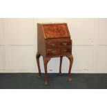 A small walnut bureau with quarter veneered fall above two drawers, on cabriole legs, 44cm