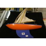 Toys: 20th cent. Treen and metal pond yacht, Star Yacht, Birkenhead in orange and blue.