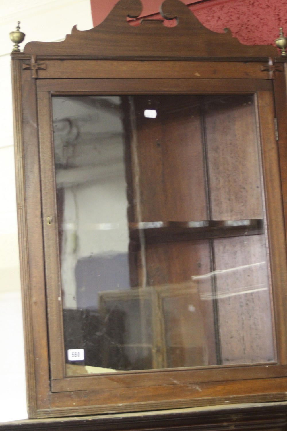 19th cent. Mahogany corner wall mounted cupboard with a single shaped shelf and glazed door.