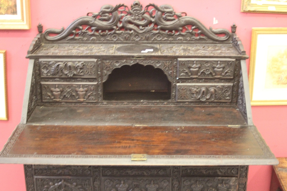 Far East: Pre-war 20th cent. heavily carved ebonised bureau the drop flap reveals a fitted - Image 2 of 2